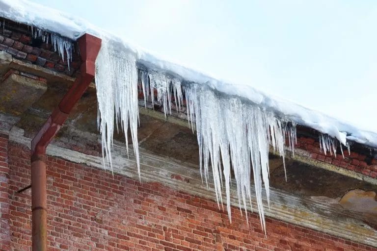 A brick house dripping with icicles