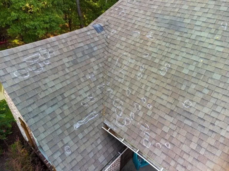 A roof marked after inspection for hail damage. Hail is a common winter roof damage
