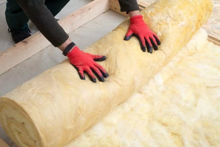 A worker doing insulation replacement with yellow insulation.