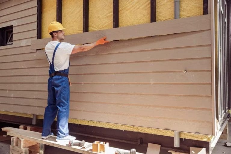 man builder building cabin at construction site using Engineered Wood Siding